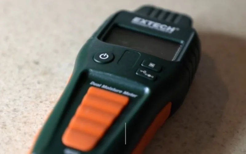 Dual pin and pinless moisture meter used to check drywall and framing for hidden moisture